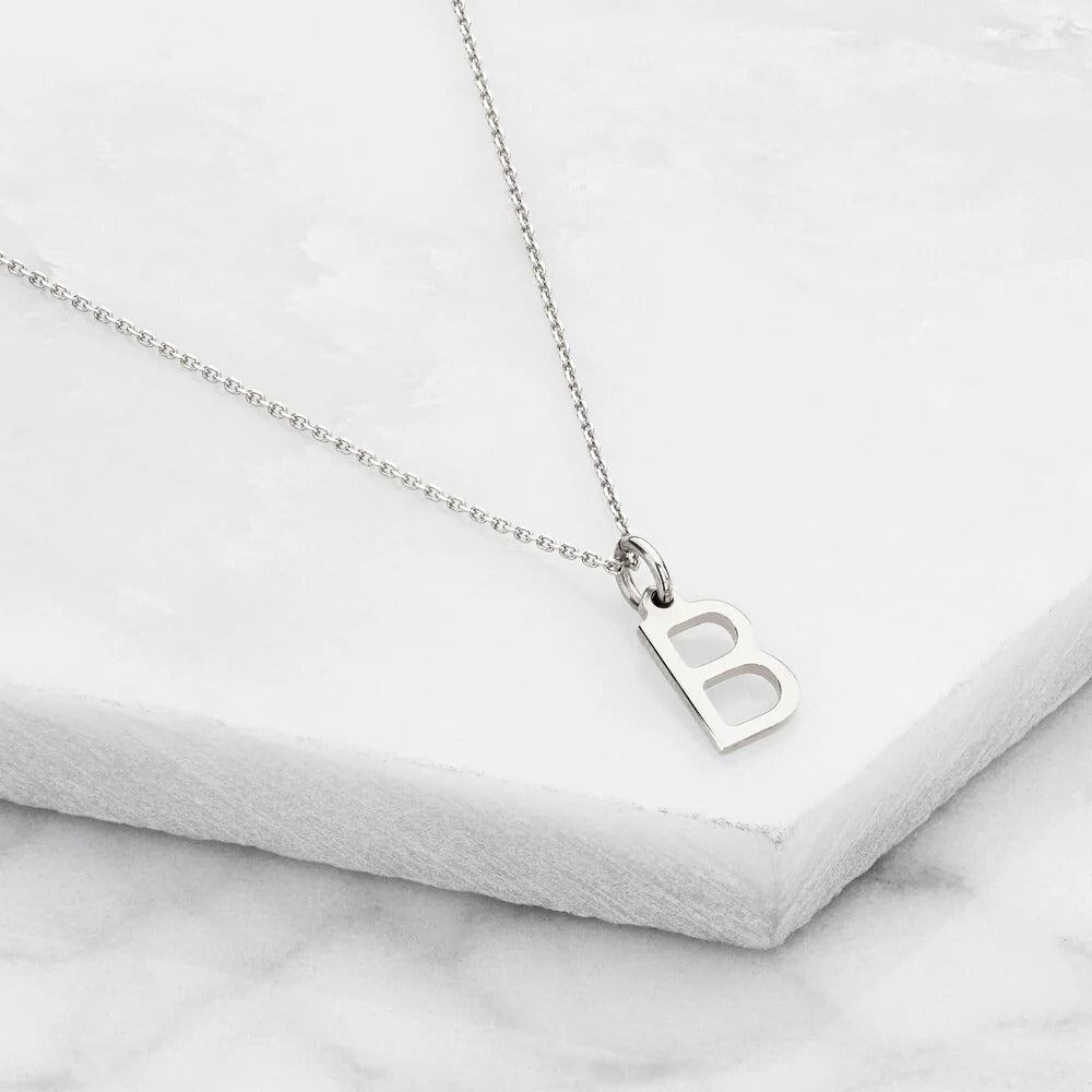 Minimalist silver necklace featuring engraved initial charm